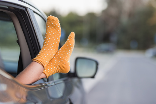 Child wearing yellow socks when sticking her feet out of the car window