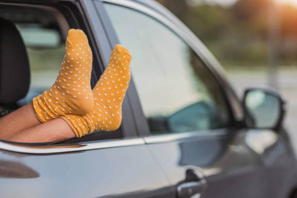 istock Girl resting feet on the car window 1339724634