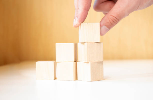 istock Hand putting and stacking blank wooden cubes on table with copy space for input wording and infographic icon. 1339725185