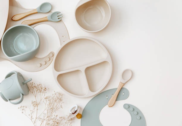 Baby Table Setting Background. Silicone set on light background. Place for text, copy space. Top view, flat lay.
