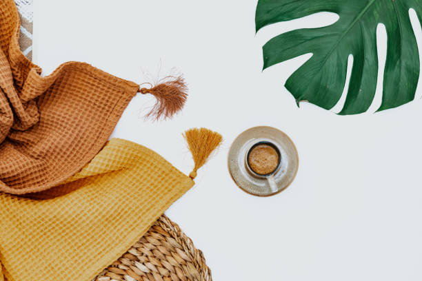 istock Two blankets, coffee cup and monstera leaf on white background, minimal simple background, workspace 1339729027