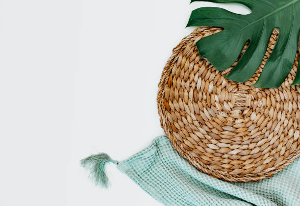 istock Flat lay monstera leaf, blanket and straw stand on white background. top view. 1339729029
