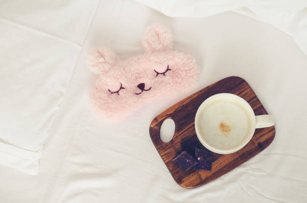 istock Cup of coffee with cute pink sleep mask 1339740362