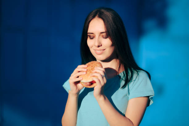 istock Beautiful Young Woman Holding a Delicious Burger 1339751002