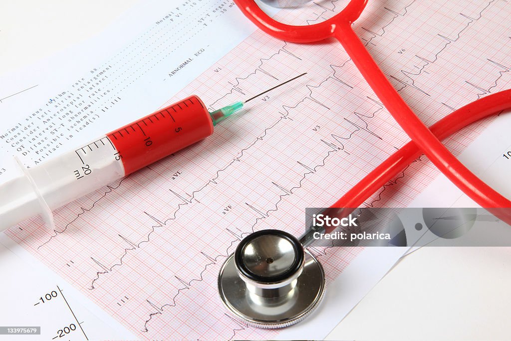 Medical series XXL Syringe and red stethoscope on an ekg Accidents and Disasters Stock Photo