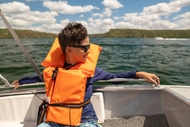 istock Boy with life jacket riding in a speedboat river 1339759096
