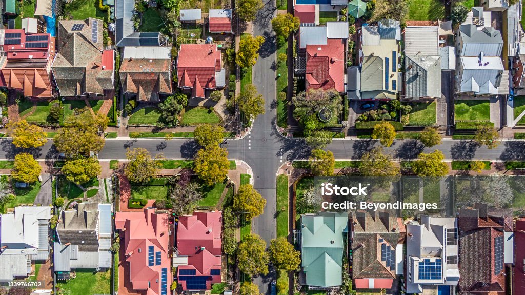 Aerial view of leafy eastern suburban houses on 4-way cross road intersection in Adelaide, South Australia Aerial view of leafy eastern suburban houses on 4-way cross road intersection in Adelaide, South Australia: directly above, rooftop solar, trees in multiple colours (yellow, green, white); front & backyard, external garage, play equipment Real Estate Stock Photo