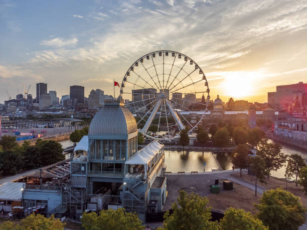 The Montreal Ferris wheel. Quebec, Canada. La Grande roue de Montreal Ferris wheel and downtown skyline in summer dusk. Quebec, Canada. quebec stock pictures, royalty-free photos & images