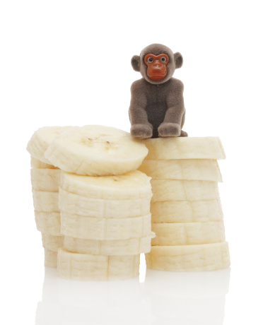 Monkey toy sitting on sliced banana