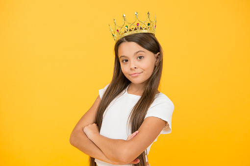 Young perfectionist. luxury and success. selfish little girl wear golden crown. small princess kid. feel like champion. happy childhood. good motivation concept. she is big boss. proud of her reward.