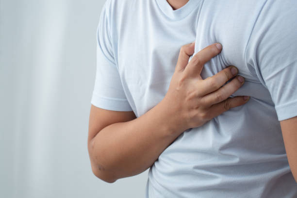 A man wearing a blue shirt has chest pain. stock photo