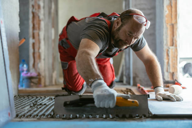 istock Man applying tile adhesive on the floor 1339779669