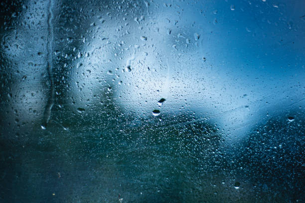 istock raindrops on glass, blue background with water drops 1339780959