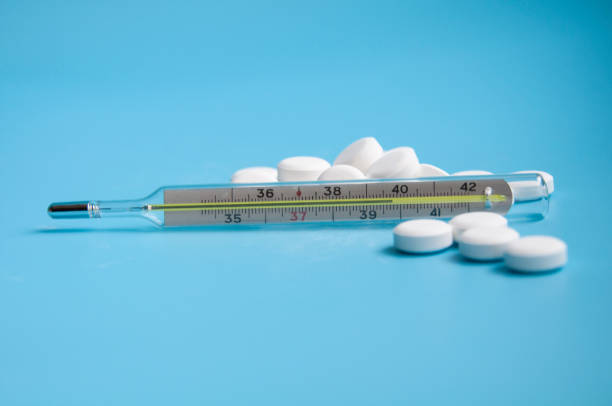istock thermometer and white pills on the blue background 1339783294