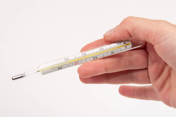 istock Medcine glass thermometer in hand on white 1339783317