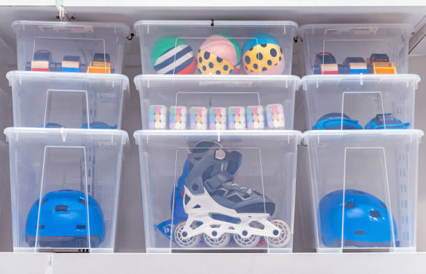 plastic boxes with children's toys, rollers and a helmet. - storage containers imagens e fotografias de stock