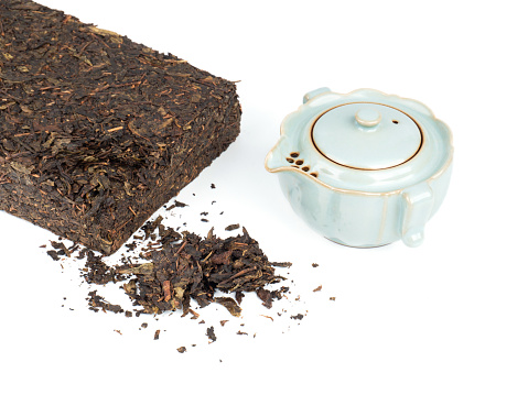 Tea brick and tea pot on white background