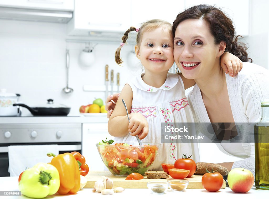 cooking together Mother and daughter cooking dinner in kitchen Adult Stock Photo