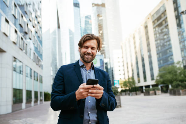 istock Mature businessman in full suit using smart phone in financial district during lockdown 1339790068