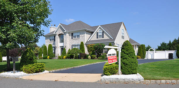 Real Estate Agent For Sale Sign on Landscaped Suburban Front Yard stock photo