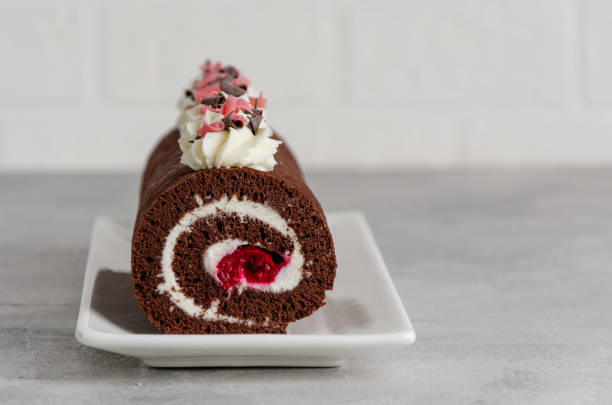 istock Black forest chocolate cake roll with whipped cream and cherry filling on a gray background. Copy space. 1339797324