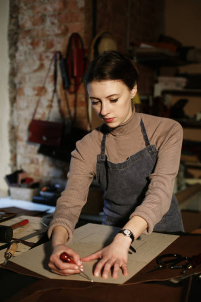 istock woman works in a bag making studio, cuts out details 1339797943