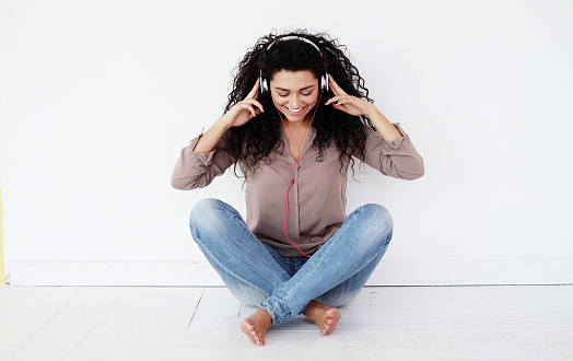 happy woman sitting at home and listening to music with headphones