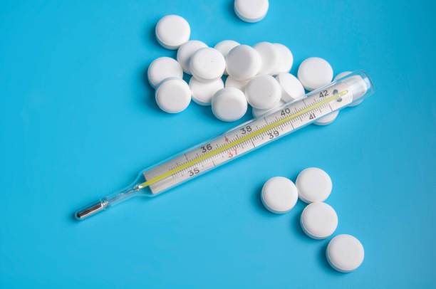 istock thermometer and white pills on the blue background 1339802189