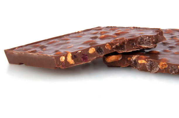 istock milk chocolate with nuts and berries brocken isolated on the white 1339802491