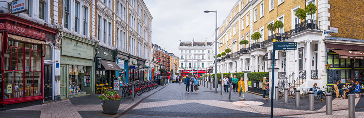People strolling through the pedestrianised streets of South Kensington between shops and cafes in the heart of London, UK.