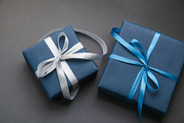 две темно-синие подарочные коробки на сером фоне. подарок для мужчин. день отцов. подарок для него. - liliya стоковые фото и изображения