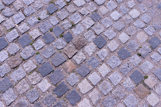 istock Old cobblestone pavement close-up background and texture 1339811350