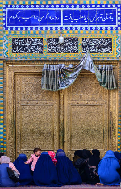 afghanische frauen in burkas - schrein von ali (hazrat ali mazar) - vergoldetes tor, mazar-i-sharif, provinz balkh, afghanistan - mazar stock-fotos und bilder