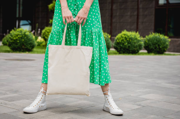 giovane donna bellissima con borsa ecologica di lino sullo sfondo della città. - false colour foto e immagini stock