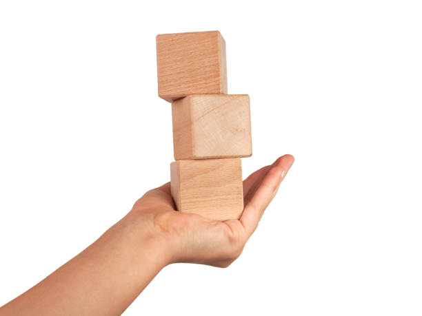 istock Wooden square cube in hand isolated on the white 1339816786