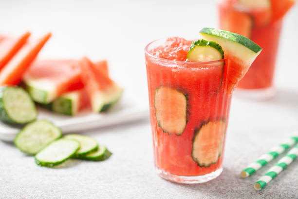 erfrischendes kaltes sommergetränk wassermelone slushie mit gurkenscheiben im glas - watermelon fruit summer portion stock-fotos und bilder