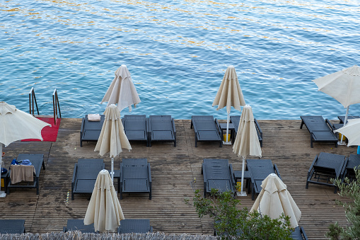 empty sun loungers on the sea shore at resort, top view