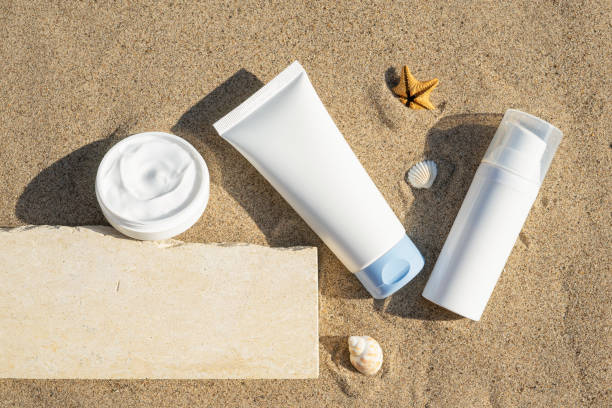 istock Unbranded cosmetic flacon with moisturizing liquid. Summer decorations, seashell and starfish, sand background. Cream or lotion. Mockup style. Beauty concept. Top view 1339819413