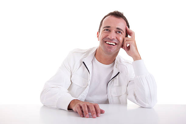 smiling middle-age man sitting at desk stock photo