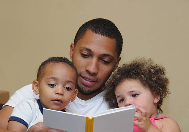 два поколения семьи читать отец сын niece - child book reading baby стоковые фото и изображения