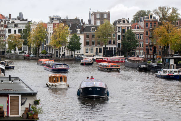 Many Canal Cruise Boats Seen From The Blauwbrug Bridge At Amsterdam The Netherlands Many Canal Cruise Boats Seen From The Blauwbrug Bridge At Amsterdam The Netherlands 12-10-2019 stopera stock pictures, royalty-free photos & images