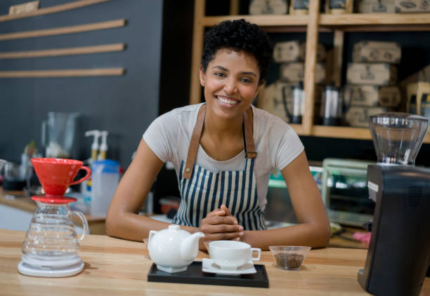 istock Happy barista working at a cafe serving coffee and smiling 1339827111