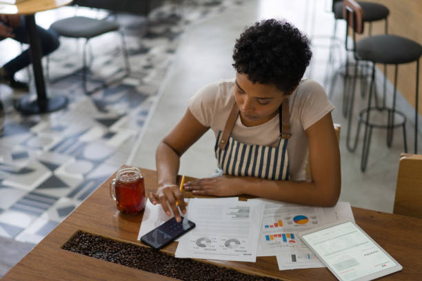 business owner doing to the books at a coffee shop - business struggle imagens e fotografias de stock