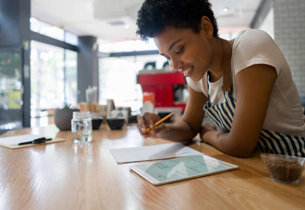 istock Business owner doing to the books at a cafe while closing her shift 1339827262