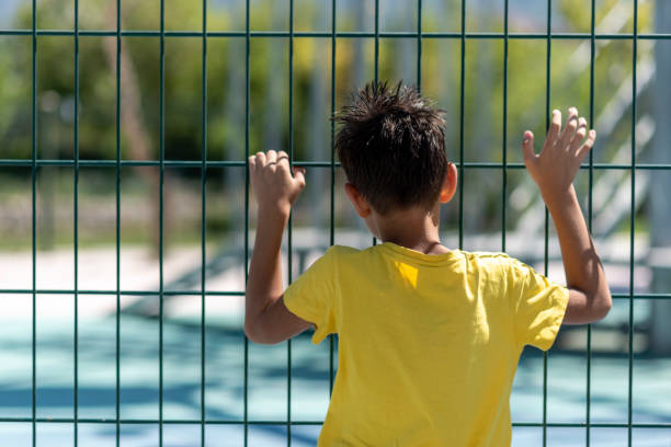 little boy behind the cage little boy behind the cage child arrest stock pictures, royalty-free photos & images