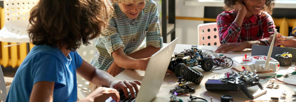 des écoliers multiethniques construisent des robots à la classe d’ingénierie stem. - computer lab child internet development photos et images de collection