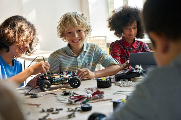 istock Happy schoolboy with group of classmates on science lab work at school. 1339828636