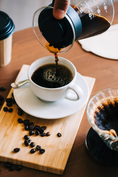 istock Man pouring coffee in a cup, alternative coffee brewing method, using pour over dripper and paper filter. 1339830438
