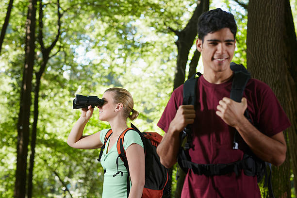 istock young man and woman hiking in forest with binoculars 133983070