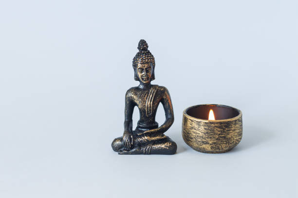 Buddha with candle on meditation buddhism altar enlightenment concept Buddha statue on altar with burning candle. Meditation, buddhism and enlightenment concept bronze statue stock pictures, royalty-free photos & images